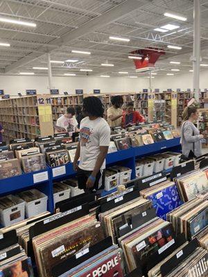 Vinyl albums section with books on sale in the background.