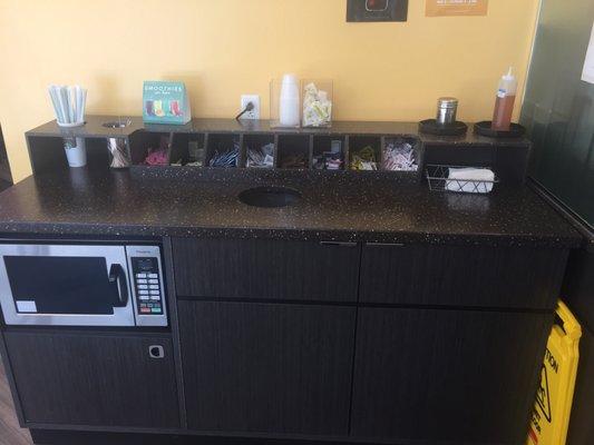 A microwave next to the Starbucks pickup counter to heat food up