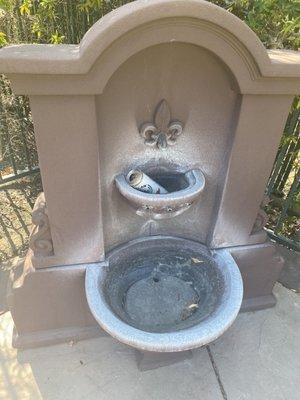 Broken pool fountain with beer can.