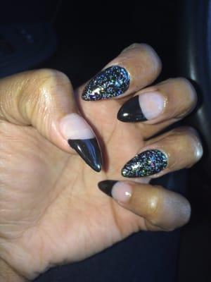 Simple stiletto look, black tips with cosmic stars index finger and ring finger filled in color.