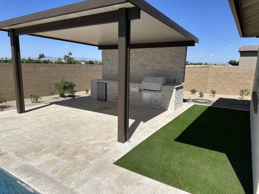 Custom Outdoor Kitchen Covered, travertine, and artificial turf.