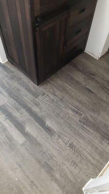 Laminate in the bathroom. We love the aged grey wood look and know it will wear well over time with any scratches