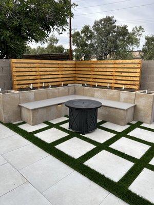 Sitting area with wood back. Porcelain paver and grass