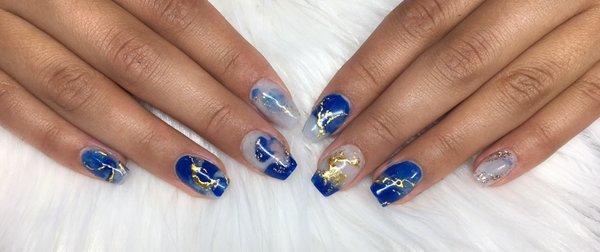 In shop blended bright blue and whispy white acrylics, the marble finished off with gold foils