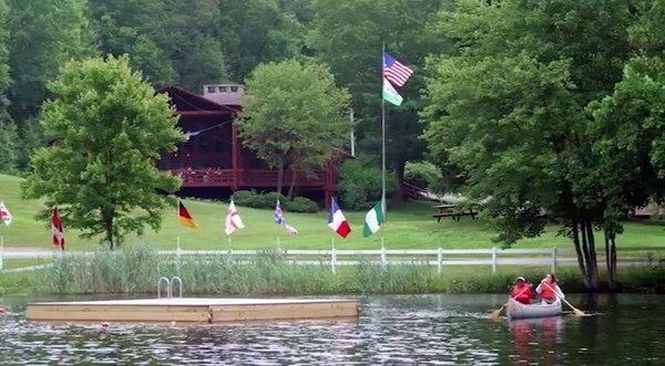 The dining hall, lake, flags, and floating dock