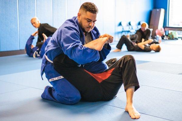 Midwest Martial Arts Academy student drilling toe hold submission during Brazilian Jiu Jitsu (BJJ).