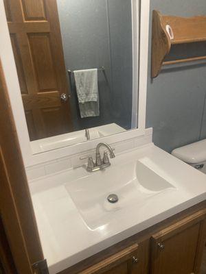 Bathroom remodel with new sink and frame on mirror