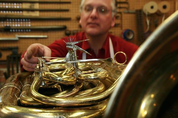 Dana setting pins on a tuba.