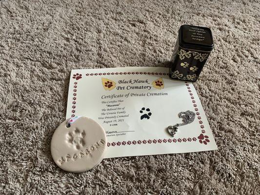 The cremation certificate from BlackHawk Pet Crematory, Mac's ashes in the tin and the necklace, and the clay paw print from CityLine