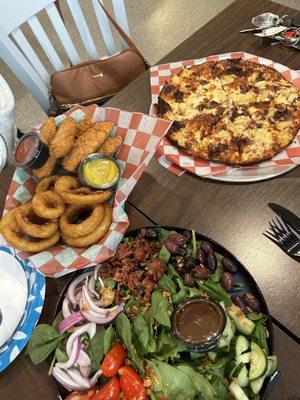 Hawaiian pizza, spinach salad, chicken fingers and onion rings