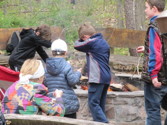 Kids roasting free marshmallows or dabbing.