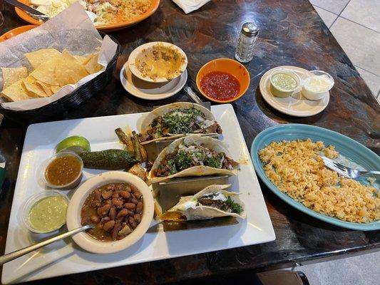 Carne Assad Tacos with a side of rice smothered in queso.