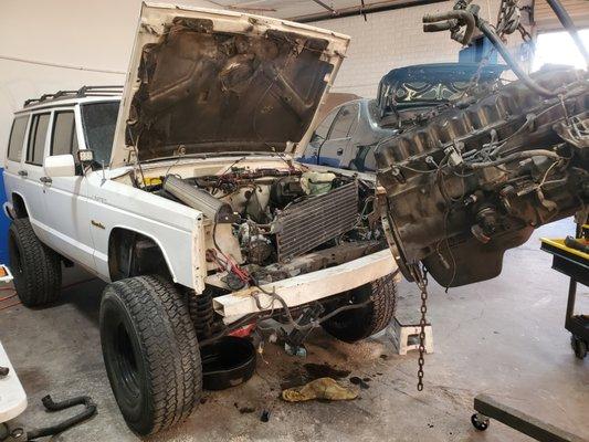 Jeep motor being pulled for rebuild.