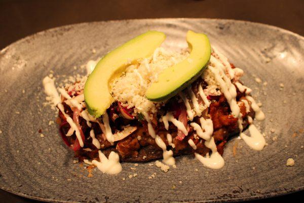 Huarache - Blue corn tortilla flatbread, layered with refried beans, your choice of filling, Mexican slaw, crema, queso fresco, and avocado