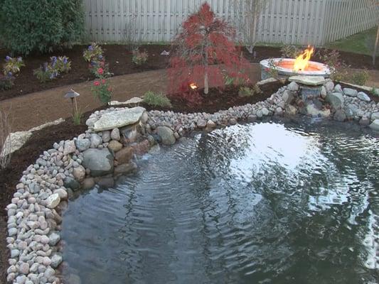 Large pond with two waterfalls and an adjacent fire feature.