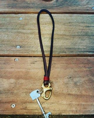 Pin spring lock key fob with leather leash.