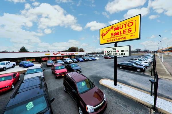 A photo of our sign, featuring our warranty, and of some vehicles.