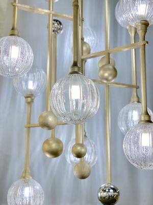 The Majorette Chandelier by Corbett features spheres of Clear and Clear Seeded glass and polished steel finish