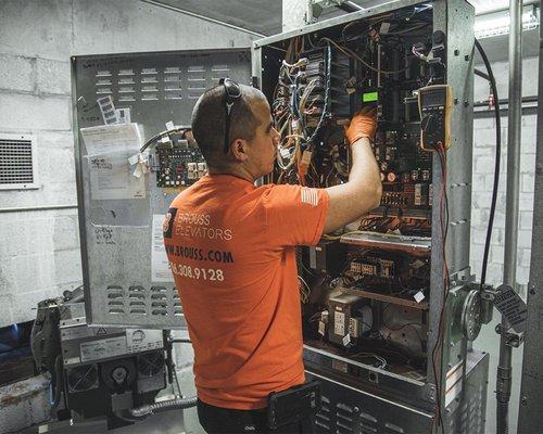 Brouss Elevators crew inspecting elevator electrical panel.