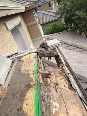 Advanced stage of wood rot on a tile roof