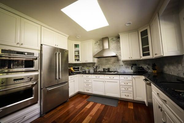 stacked ovens and huge fridge in with clean lines and great functionality