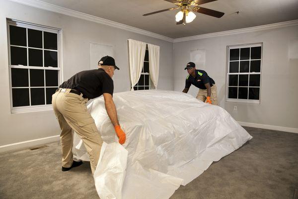 Technicians protecting the customer's furniture prior to cleaning.