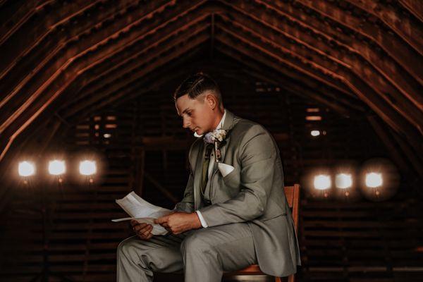 Groom reads letter from his bride at Wheeler Farms in white house Ohio.