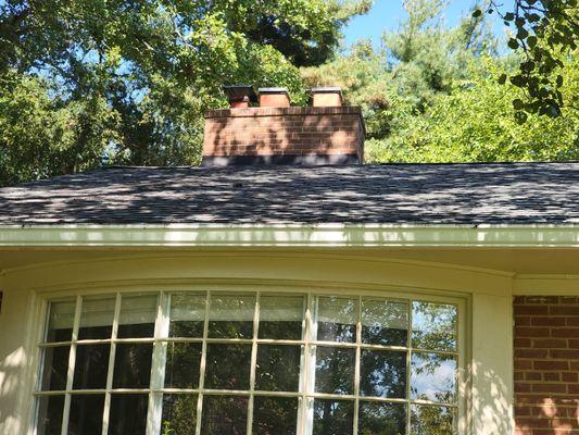 Chimney with three separate chimneys coming out of structure.