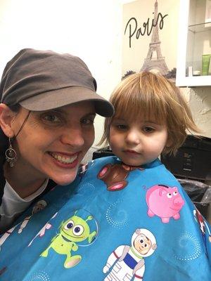 Cute little baby girl getting a haircut took a photo with mama