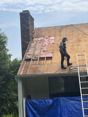 Workers are removing roof tiles in order to replace with new ones