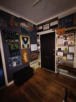 Entryway door with a local artists wall on your left