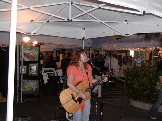 Live music is always at the market.  Here Myrna Sanders entertains with original songs.