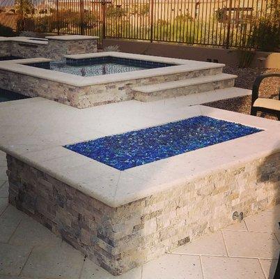 Rectangular firepit with travertine ledgestone.