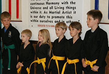 A group of our Tae Kwon Do kids, lined up listening to their instructor.