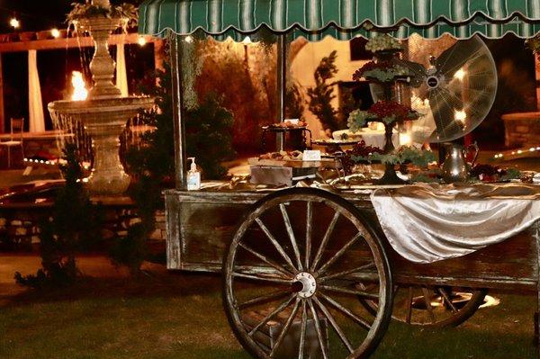 Old wagon with hor dourves.  Beautiful fountain in the background.