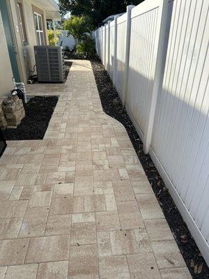 New paver walkway from the back yard to the front of the house with pad for garbage and recycling cans.