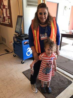 6.6.22 Technical Inspector Poll Worker with our very first voter of the day, Alexandra posing for her shy mom at 8:42am