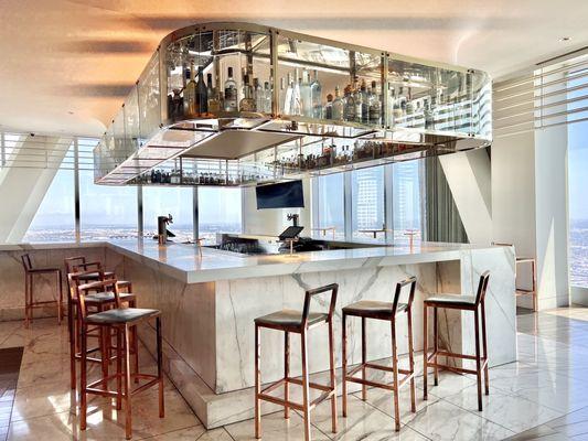 Marble bar with suspended glass shelf where liquor bottles are showcased. Views are awesome!