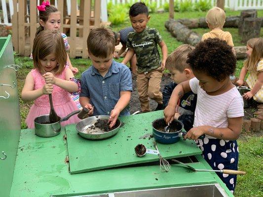 Getting dirty in our mud kitchen!