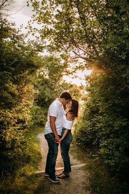 Intimate moment underneath trees on a path in Cape Elizabeth Maine for couples engagement session