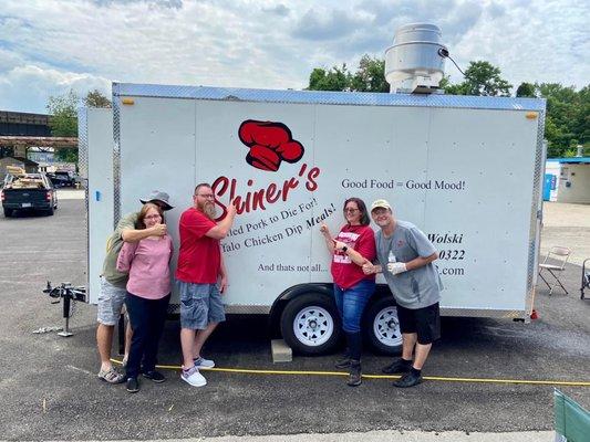 Picture of the back of the food truck with a group of people that just ate wonderful food from there!