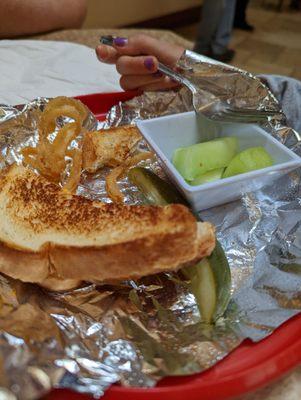 Half eaten children's menu grilled cheese with a pickle and fruit. Could have had fries, but fresh fruit hit the spot for our granddaughter.