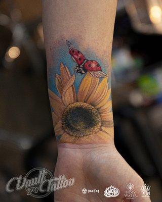 Best sunflower and ladybug tattoo on the wrist done in color