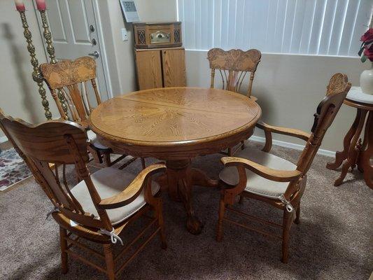 Kitchen table with 4 chairs. 43" round. Has hidden extender that lifts out to make table larger and oval shape.