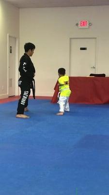 Master Kim helping prepare for the belt test!  Love that even with a class he still gives the children one on one time!