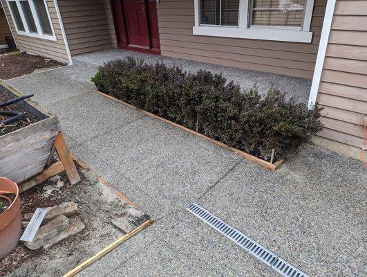 this corner was a huge problem in our old driveway resulting in pooled water.  note the lines they put into the driveway into the drain