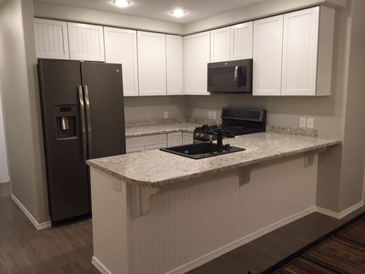 Aristokraft cabinetry with laminate post-formed countertops. Beadboard wainscoting was used for the back of peninsula.