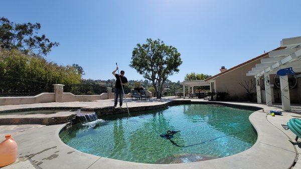 Josh, the owner, cleaning a pool in Whittier.