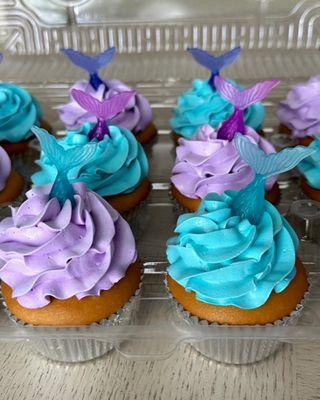 Mermaid-themed vanilla cupcakes with whipped cream frosting.