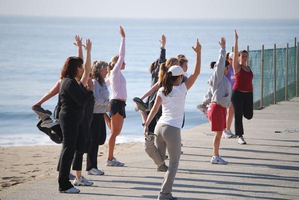 Getting in a good post-camp stretch at the beach at Adventure Boot Camp in Pacific Palisades